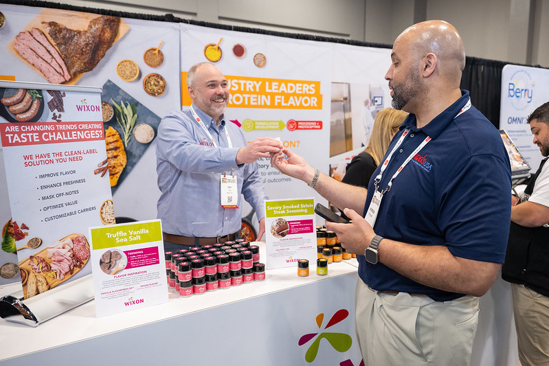 Man sampling seasoning at exhibit