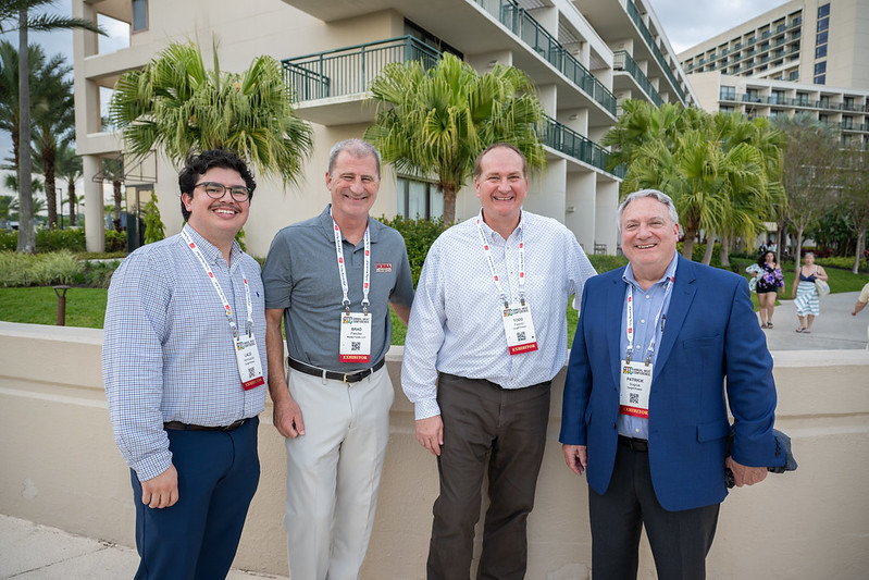Four men posing in front of hotel