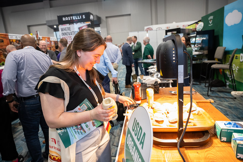 Woman sampling sliders at Annual Meat Conference